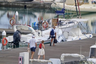 İtalya, Sicilya, Akdeniz, Marina di Ragusa (Ragusa Eyaleti); 19 Eylül 2019' da limanda insanlar, motorlu tekneler ve lüks yatlar - Editörden