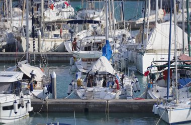 İtalya, Sicilya, Akdeniz, Marina di Ragusa (Ragusa Eyaleti); 21 Eylül 2019, limanda insanlar ve yelkenli tekneler - Editörden