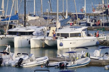 İtalya, Sicilya, Akdeniz, Marina di Ragusa (Ragusa Eyaleti); 23 Eylül 2019, limanda bir yelkenli teknede adam - Editörden