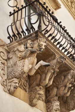 İtalya, Sicilya, Scicli (Ragusa ili), Unesco Baroque Fava Sarayı cephesi, bir balkon altında süslü heykeller (M.S. 18..)