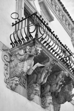 İtalya, Sicilya, Scicli (Ragusa ili), Unesco Baroque Fava Sarayı cephesi, bir balkon altında süslü heykeller (M.S. 18..)