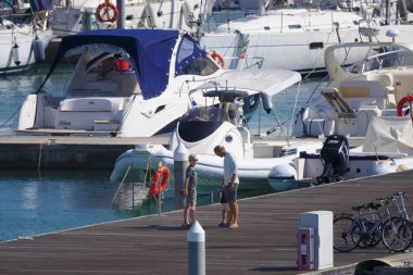 İtalya, Sicilya, Akdeniz, Marina di Ragusa (Ragusa Eyaleti); 28 Eylül 2019, limanda insanlar, motorlu tekneler ve lüks yatlar - Editörden