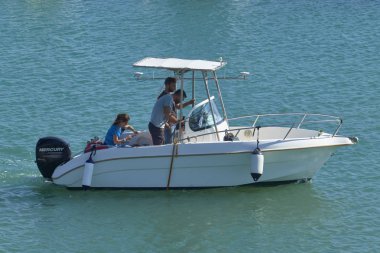 İtalya, Sicilya, Akdeniz, Marina di Ragusa (Ragusa Eyaleti); 28 Eylül 2019, limanda bir motorlu teknede insanlar - Editörden