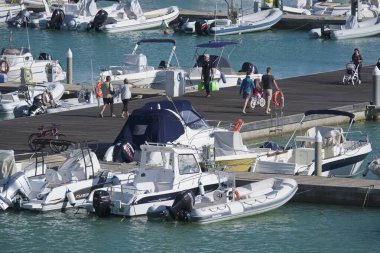 İtalya, Sicilya, Akdeniz, Marina di Ragusa (Ragusa Eyaleti); 5 Ekim 2019, limandaki insanlar, motorlu tekneler ve lüks yatlar