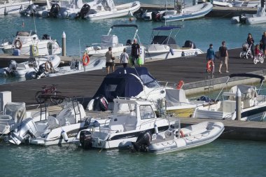 İtalya, Sicilya, Akdeniz, Marina di Ragusa (Ragusa Eyaleti); 5 Ekim 2019, limandaki insanlar, motorlu tekneler ve lüks yatlar