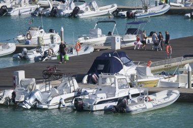 İtalya, Sicilya, Akdeniz, Marina di Ragusa (Ragusa Eyaleti); 5 Ekim 2019, limandaki insanlar, motorlu tekneler ve lüks yatlar
