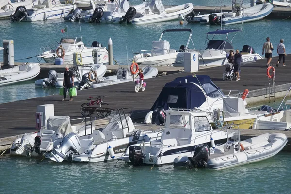 İtalya, Sicilya, Akdeniz, Marina di Ragusa (Ragusa Eyaleti); 5 Ekim 2019, limandaki insanlar, motorlu tekneler ve lüks yatlar
