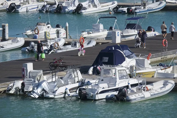 İtalya, Sicilya, Akdeniz, Marina di Ragusa (Ragusa Eyaleti); 5 Ekim 2019, limandaki insanlar, motorlu tekneler ve lüks yatlar