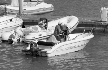 İtalya, Sicilya, Akdeniz, Marina di Ragusa (Ragusa Eyaleti); 31 Mayıs 2020, limandaki bir motorlu teknede adam - EDITORIAL