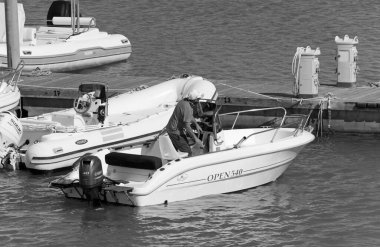 İtalya, Sicilya, Akdeniz, Marina di Ragusa (Ragusa Eyaleti); 31 Mayıs 2020, limandaki bir motorlu teknede adam - EDITORIAL