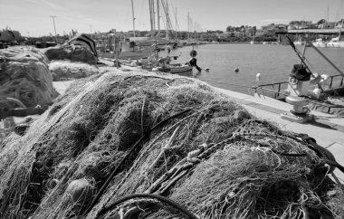 İtalya, Sicilya, Marina di Ragusa (Ragusa Eyaleti), ağlar, yerel ahşap balıkçı tekneleri ve limanda lüks yatlar