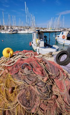 İtalya, Sicilya, Marina di Ragusa (Ragusa Eyaleti), ağlar, yerel ahşap balıkçı tekneleri ve limanda lüks yatlar