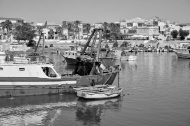 İtalya, Akdeniz, Sicilya, Scoglitti (Ragusa Eyaleti); limanda ahşap bir balıkçı teknesinde çalışan balıkçılar 