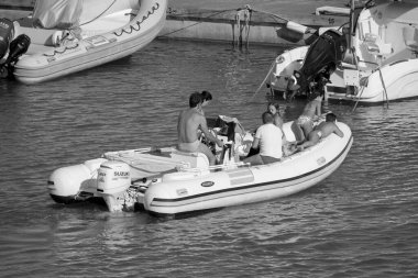 İtalya, Sicilya, Akdeniz, Marina di Ragusa (Ragusa Eyaleti); 28 Haziran 2020, limandaki kauçuk tekne ve lüks yatlarda yaşayan insanlar - EDITORIAL