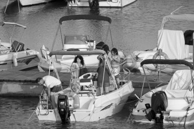 İtalya, Sicilya, Akdeniz, Marina di Ragusa (Ragusa Eyaleti); 29 Haziran 2020, gün batımında limanda bir motorlu teknede insanlar - EDITORIAL