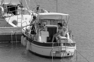 İtalya, Sicilya, Akdeniz, Marina di Ragusa (Ragusa Eyaleti); 2 Temmuz 2020, limanda lüks bir yatta insanlar - EDITORIAL