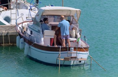 İtalya, Sicilya, Akdeniz, Marina di Ragusa (Ragusa Eyaleti); 2 Temmuz 2020, limanda lüks bir yatta insanlar - EDITORIAL