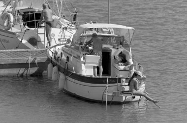 İtalya, Sicilya, Akdeniz, Marina di Ragusa (Ragusa Eyaleti); 2 Temmuz 2020, limanda lüks bir yatta insanlar - EDITORIAL