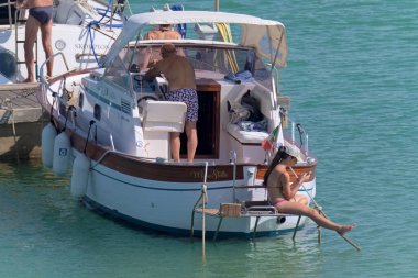 İtalya, Sicilya, Akdeniz, Marina di Ragusa (Ragusa Eyaleti); 2 Temmuz 2020, limanda lüks bir yatta insanlar - EDITORIAL