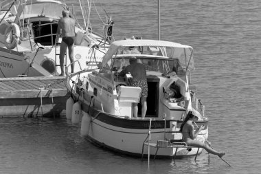 İtalya, Sicilya, Akdeniz, Marina di Ragusa (Ragusa Eyaleti); 2 Temmuz 2020, limanda lüks bir yatta insanlar - EDITORIAL