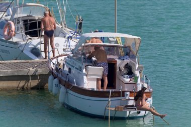 İtalya, Sicilya, Akdeniz, Marina di Ragusa (Ragusa Eyaleti); 2 Temmuz 2020, limanda lüks bir yatta insanlar - EDITORIAL