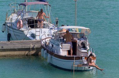 İtalya, Sicilya, Akdeniz, Marina di Ragusa (Ragusa Eyaleti); 2 Temmuz 2020, limandaki lüks yatlarda yaşayan insanlar - EDITORIAL