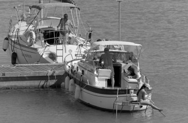 İtalya, Sicilya, Akdeniz, Marina di Ragusa (Ragusa Eyaleti); 2 Temmuz 2020, limandaki lüks yatlarda yaşayan insanlar - EDITORIAL