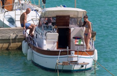 İtalya, Sicilya, Akdeniz, Marina di Ragusa (Ragusa Eyaleti); 5 Temmuz 2020, limanda lüks bir yatta insanlar - EDITORIAL