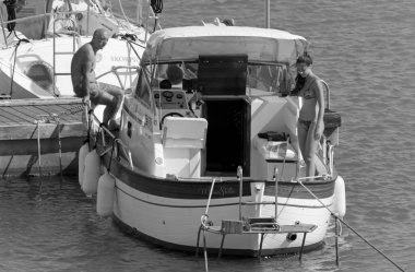 İtalya, Sicilya, Akdeniz, Marina di Ragusa (Ragusa Eyaleti); 5 Temmuz 2020, limanda lüks bir yatta insanlar - EDITORIAL