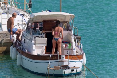 İtalya, Sicilya, Akdeniz, Marina di Ragusa (Ragusa Eyaleti); 5 Temmuz 2020, limanda lüks bir yatta insanlar - EDITORIAL