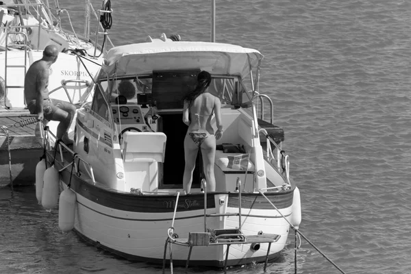 İtalya, Sicilya, Akdeniz, Marina di Ragusa (Ragusa Eyaleti); 5 Temmuz 2020, limanda lüks bir yatta insanlar - EDITORIAL