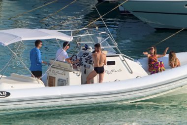 İtalya, Sicilya, Akdeniz, Marina di Ragusa (Ragusa Eyaleti); 6 Temmuz 2020, limandaki kauçuk tekne ve lüks yatlarda yaşayan insanlar - EDITORIAL