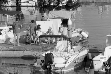 İtalya, Sicilya, Akdeniz, Marina di Ragusa (Ragusa ili); 13 Temmuz 2020, limanda insanlar ve motorlu tekneler - EDITORIAL