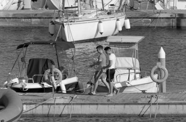 İtalya, Sicilya, Akdeniz, Marina di Ragusa (Ragusa ili); 17 Temmuz 2020, limandaki insanlar, motorlu tekneler ve lüks yatlar - EDITORIAL