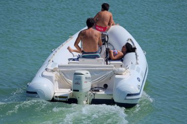 İtalya, Sicilya, Akdeniz, Marina di Ragusa (Ragusa Eyaleti); 18 Temmuz 2020, limandaki kauçuk bir teknede insanlar - EDITORIAL