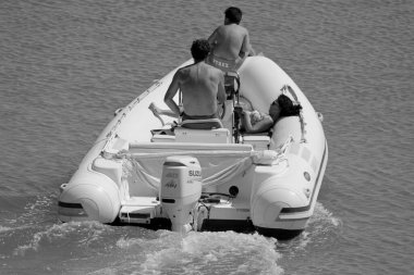 İtalya, Sicilya, Akdeniz, Marina di Ragusa (Ragusa Eyaleti); 18 Temmuz 2020, limandaki kauçuk bir teknede insanlar - EDITORIAL