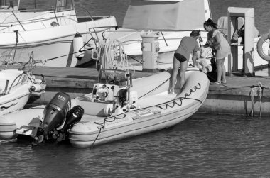 İtalya, Sicilya, Akdeniz, Marina di Ragusa (Ragusa Eyaleti); 18 Temmuz 2020, limandaki insanlar, motorlu tekneler ve lüks yatlar - EDITORIAL