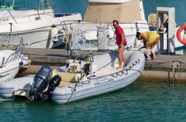 İtalya, Sicilya, Akdeniz, Marina di Ragusa (Ragusa Eyaleti); 18 Temmuz 2020, limandaki insanlar, motorlu tekneler ve lüks yatlar - EDITORIAL