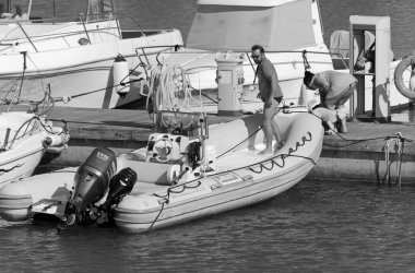 İtalya, Sicilya, Akdeniz, Marina di Ragusa (Ragusa Eyaleti); 18 Temmuz 2020, limandaki insanlar, motorlu tekneler ve lüks yatlar - EDITORIAL