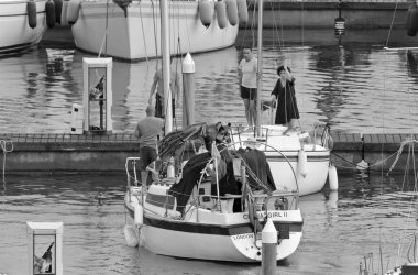 İtalya, Sicilya, Akdeniz, Marina di Ragusa (Ragusa ili); 19 Temmuz 2020, limandaki bir yelkenli teknesinde insanlar - EDITORIAL