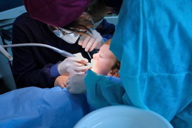 4 yaşındaki erkek çocuk bir dişçi kliniğinde tedavi ediliyor.