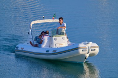 İtalya, Sicilya, Akdeniz, Marina di Ragusa (Ragusa Eyaleti); 25 Temmuz 2020, limandaki kauçuk bir teknede insanlar - EDITORIAL