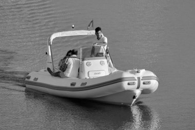 İtalya, Sicilya, Akdeniz, Marina di Ragusa (Ragusa Eyaleti); 25 Temmuz 2020, limandaki kauçuk bir teknede insanlar - EDITORIAL