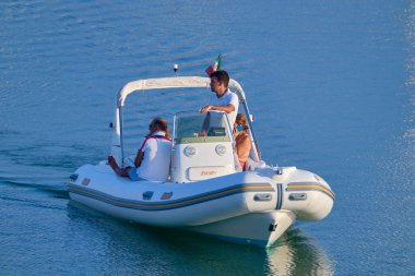 İtalya, Sicilya, Akdeniz, Marina di Ragusa (Ragusa Eyaleti); 25 Temmuz 2020, limandaki kauçuk bir teknede insanlar - EDITORIAL