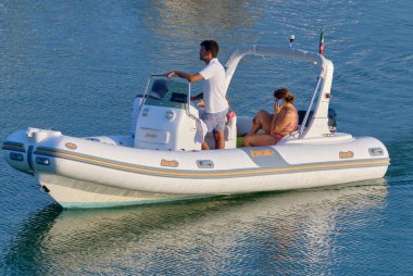 İtalya, Sicilya, Akdeniz, Marina di Ragusa (Ragusa Eyaleti); 25 Temmuz 2020, limandaki kauçuk bir teknede insanlar - EDITORIAL