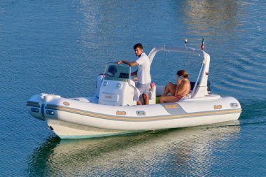 İtalya, Sicilya, Akdeniz, Marina di Ragusa (Ragusa Eyaleti); 25 Temmuz 2020, limandaki kauçuk bir teknede insanlar - EDITORIAL