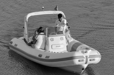 İtalya, Sicilya, Akdeniz, Marina di Ragusa (Ragusa Eyaleti); 25 Temmuz 2020, limandaki kauçuk bir teknede insanlar - EDITORIAL