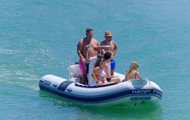 İtalya, Sicilya, Akdeniz, Marina di Ragusa (Ragusa Eyaleti); 26 Temmuz 2020, limandaki kauçuk bir teknede insanlar - EDITORIAL