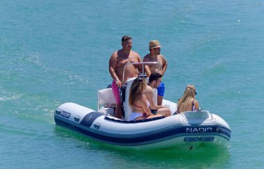 İtalya, Sicilya, Akdeniz, Marina di Ragusa (Ragusa Eyaleti); 26 Temmuz 2020, limandaki kauçuk bir teknede insanlar - EDITORIAL