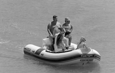 İtalya, Sicilya, Akdeniz, Marina di Ragusa (Ragusa Eyaleti); 26 Temmuz 2020, limandaki kauçuk bir teknede insanlar - EDITORIAL